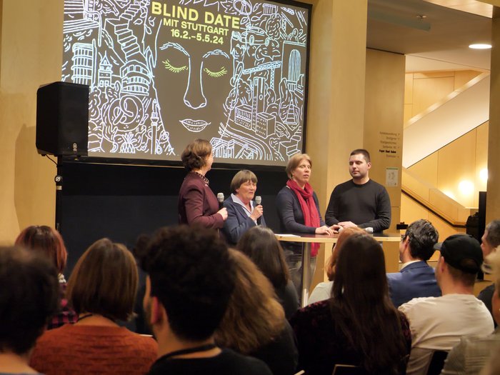 Eröffnung der Ausstellung "Blind Date mit Stuttgart". Sehbehinderte Guides stehen auf einer Bühne 